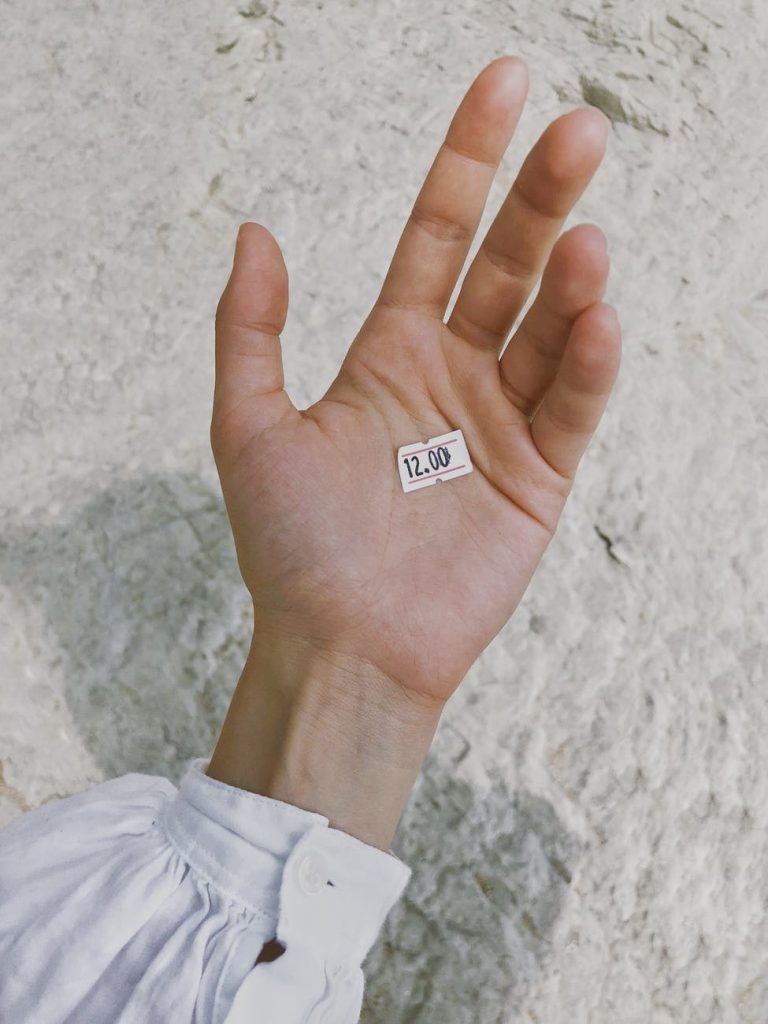 white price tag on human palm