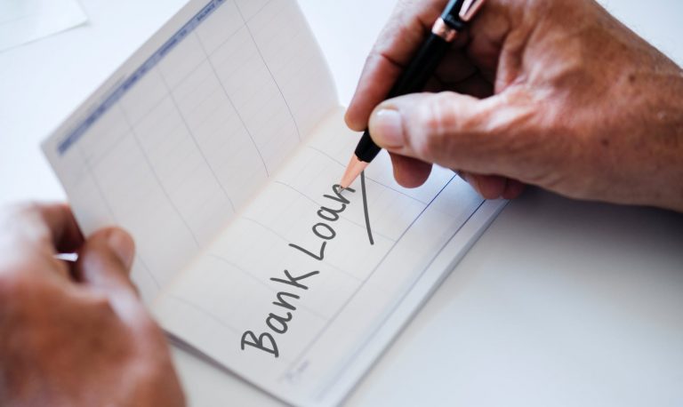 person writing bank loan on paper